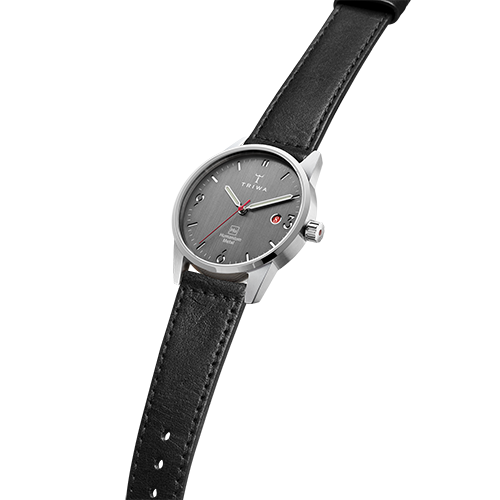 Partial side view of Humanium metal watch by Triwa, black strap and dark grey dial. Sold at UNDP Shop