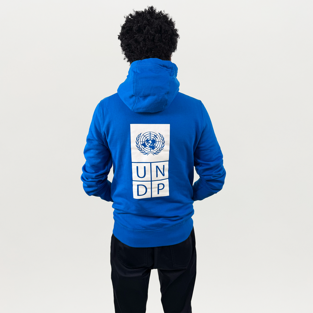 A woman wearing a blue hoodie with a white UNDP logo on the right.