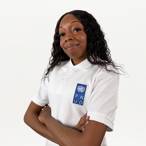 A woman wearing a white polo shirt with a blue and white PNUD logo on the right 