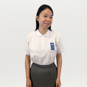 A woman wearing a white polo shirt with a blue and white UNDP logo on the right. 